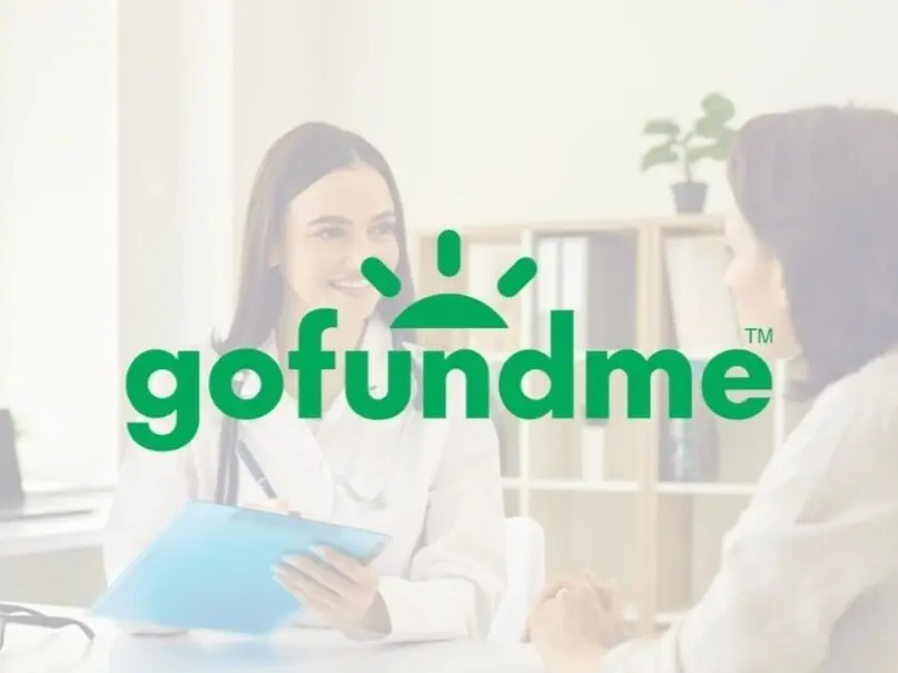 The GoFundMe logo overlaid on a background image of a doctor speaking with a patient, illustrating the topic of using crowdfunding versus travel insurance for medical emergencies.