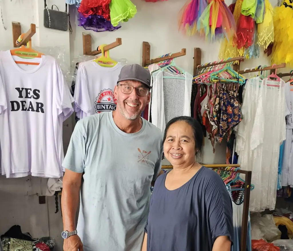 Ketut Nurani smiling with a visitor inside her popular shop on Garlic Lane in Legian, Bali