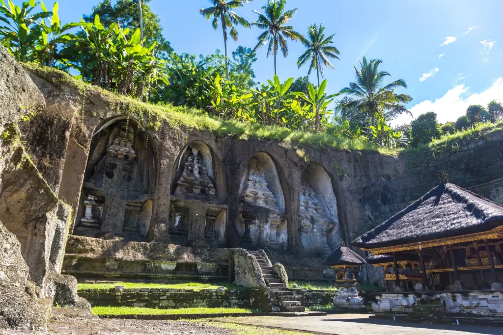 Cliff-carved shrines at Pura Gunung Kawi Bali in Tampaksiring surrounded by tropical greenery