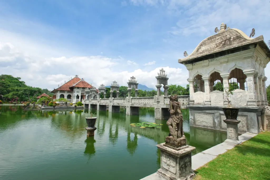 Historic Puri Agung Karangasem water palace near Seraya Bali with stone bridge, statues, and reflections on the pond
