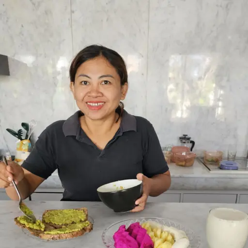 Wayan Yudi Kusumawati preparing food in a Bali villa kitchen, reflecting her life of service and dedication in Seminyak.